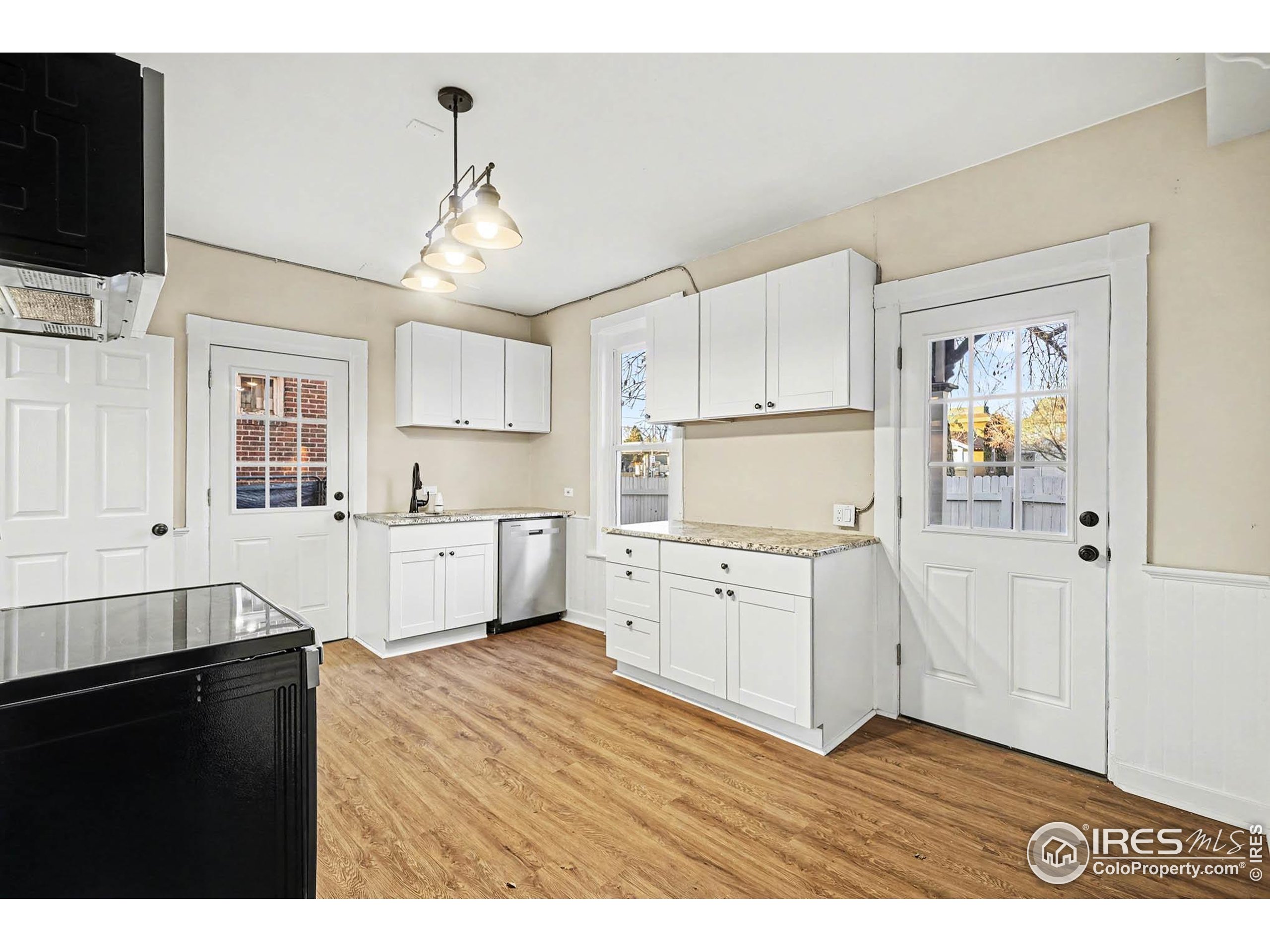 1330 8th Street Greeley, CO 80631 - Photo 12 of 27 a kitchen with granite countertop a sink cabinets and window