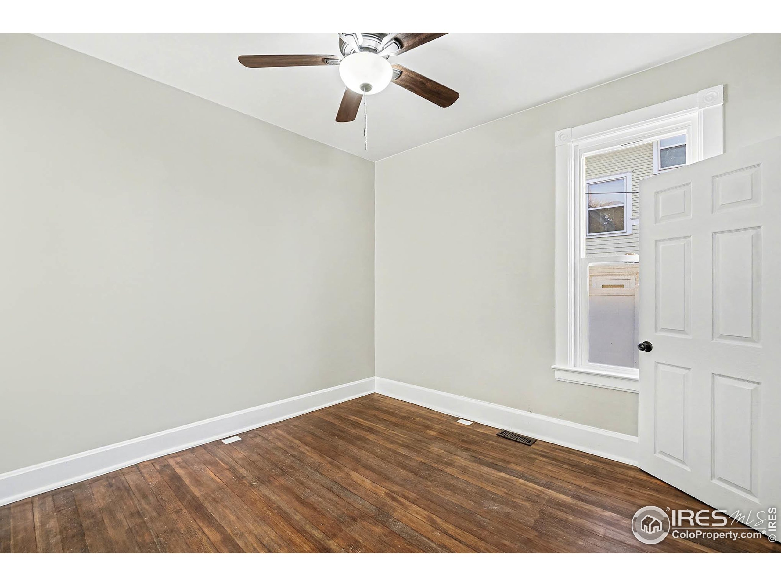 1330 8th Street Greeley, CO 80631 - Photo 17 of 27 an empty room with wooden floor ceiling fan and window