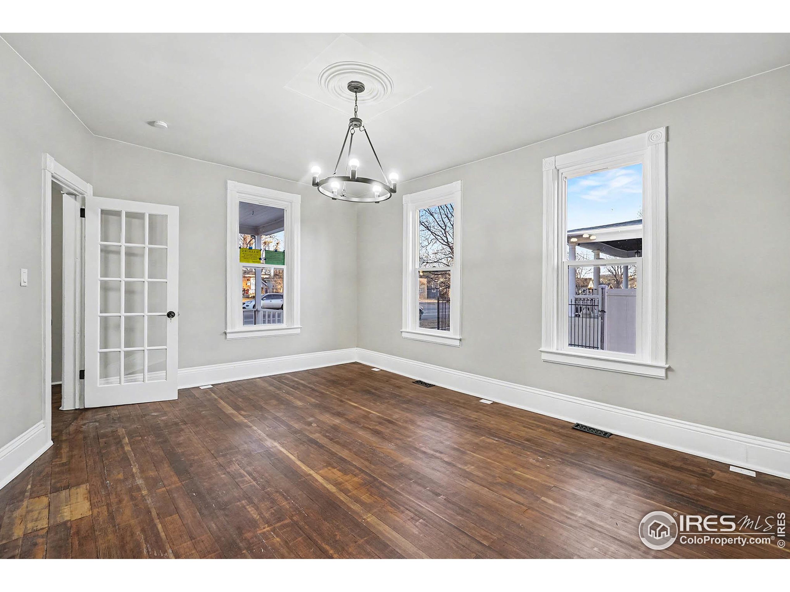 1330 8th Street Greeley, CO 80631 - Photo 6 of 27 a view of an empty room with wooden floor and a window