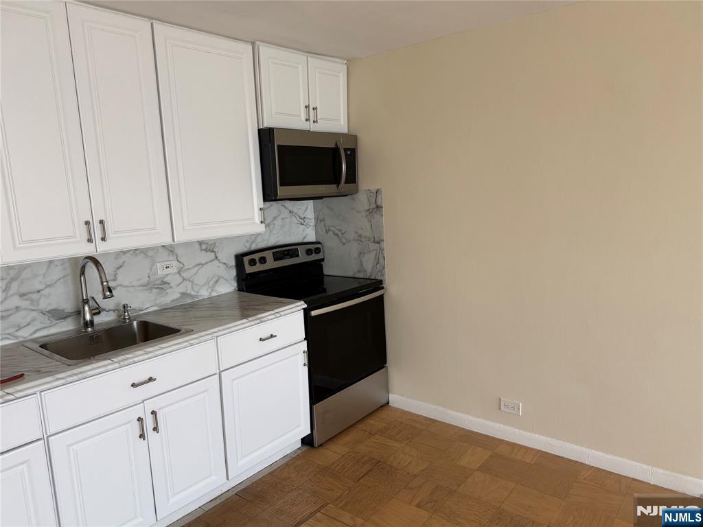 265 Main Street, Unit 702 Ridgefield Park, NJ 07660 - Photo 12 of 20 a view of a kitchen with white cabinets