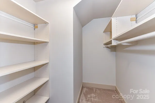 a view of walk in closet with empty racks