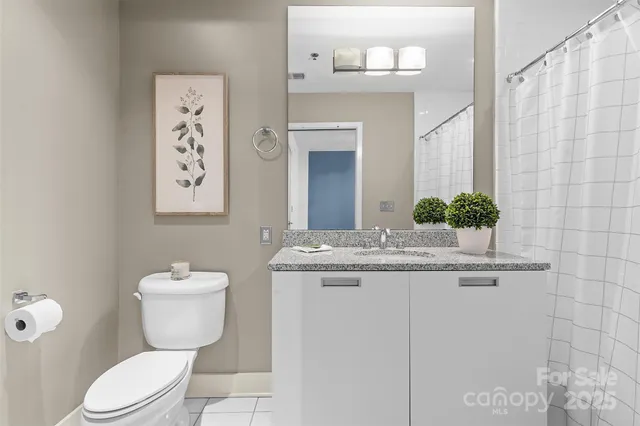 a bathroom with a granite countertop toilet sink and mirror