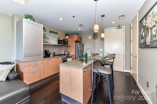 a kitchen with a table chairs stove and wooden floor