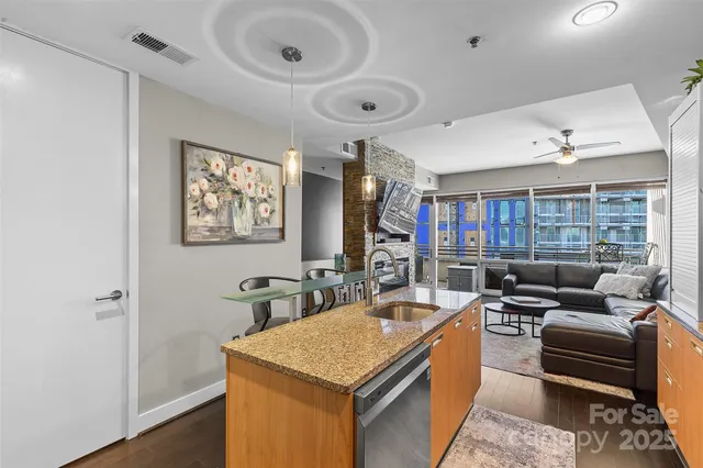 a living room with stainless steel appliances furniture a rug and a window