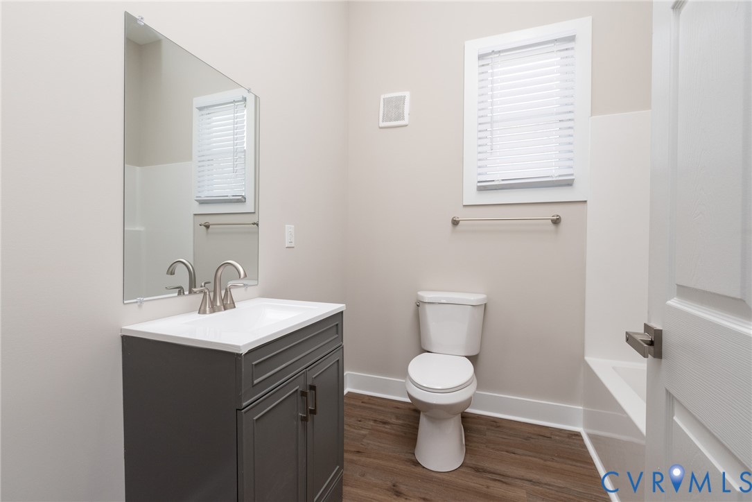 9800 Golf Course Drive Disputanta, VA 23842 - Photo 7 of 19 a bathroom with a toilet sink and mirror