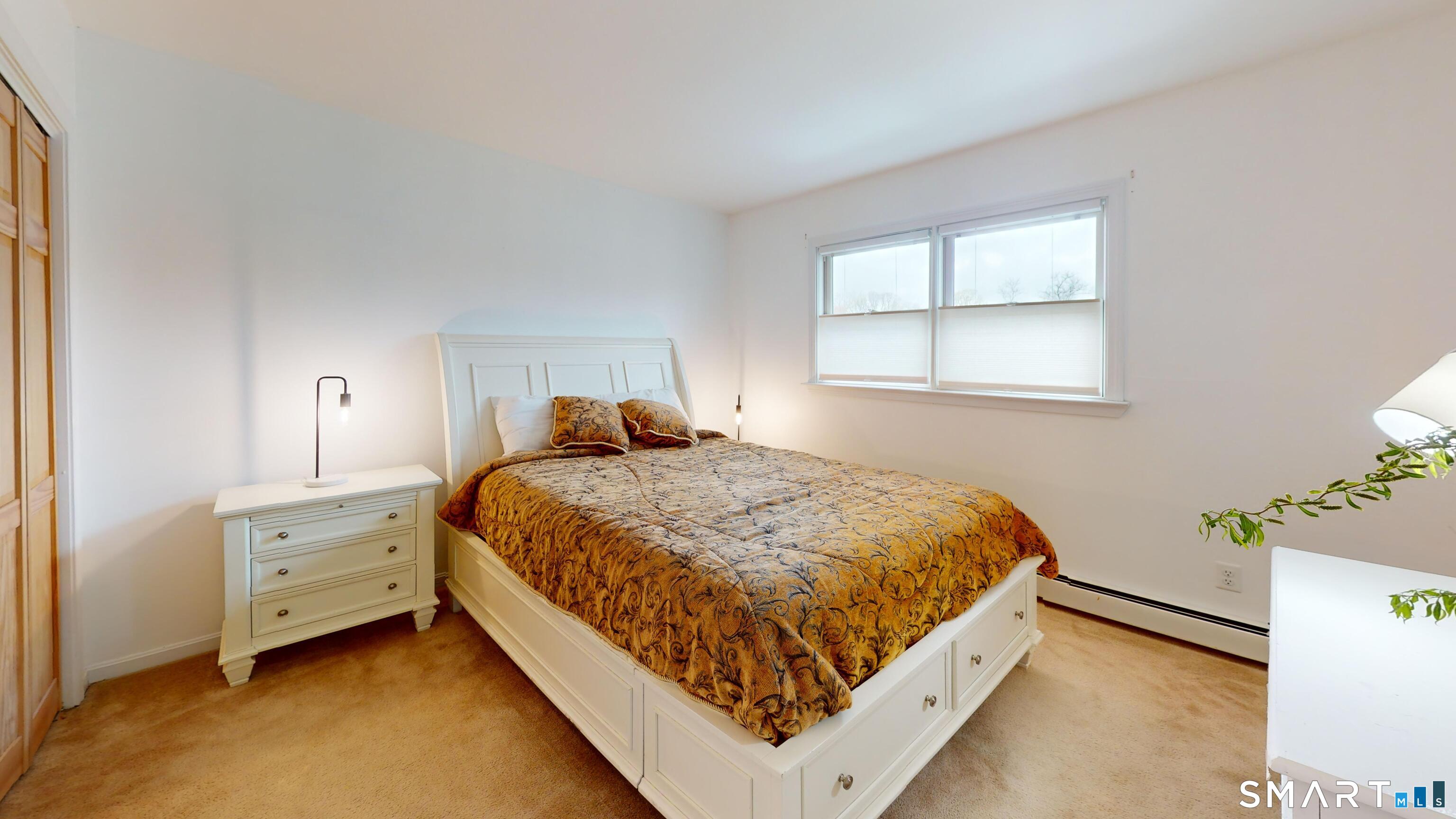 29 Deer Ridge Road Stonington, CT 06378 - Photo 17 of 35 a bed sitting in a bedroom next to a window