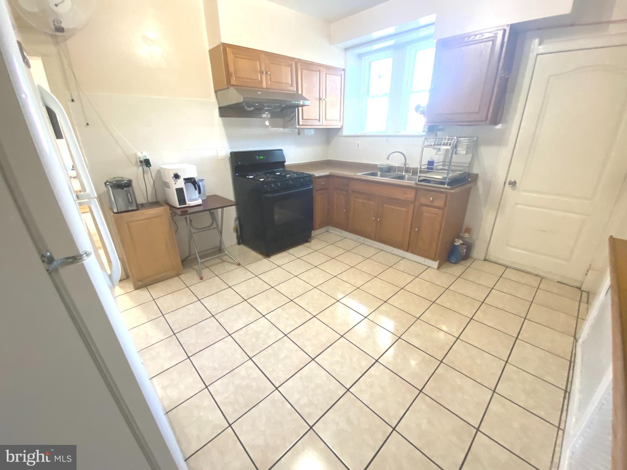 2249 Knorr Street Philadelphia, PA 19149 - Photo 22 of 40 a kitchen with stainless steel appliances a sink a window and white cabinets