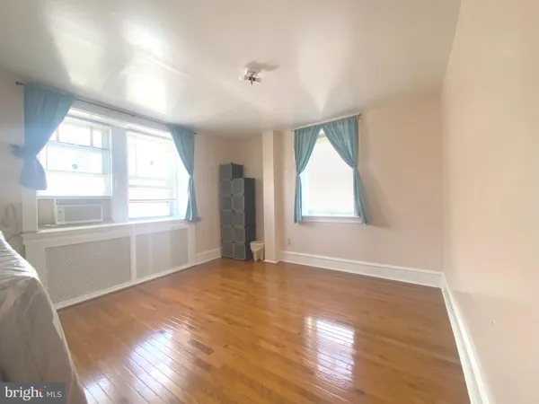 a living room with a bed furniture and a large window