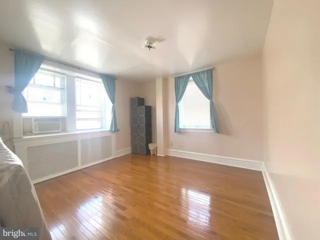 a living room with a bed furniture and a large window