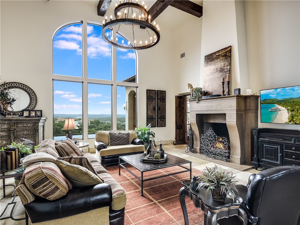 a living room with furniture a fireplace and a floor to ceiling window
