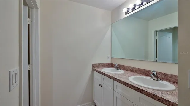 a bathroom with a double vanity sink and a mirror