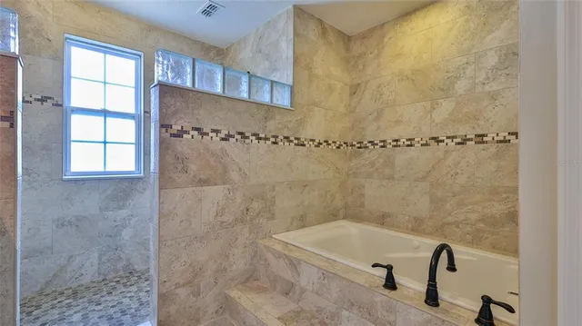 a bathroom with a granite countertop sink a mirror and shower