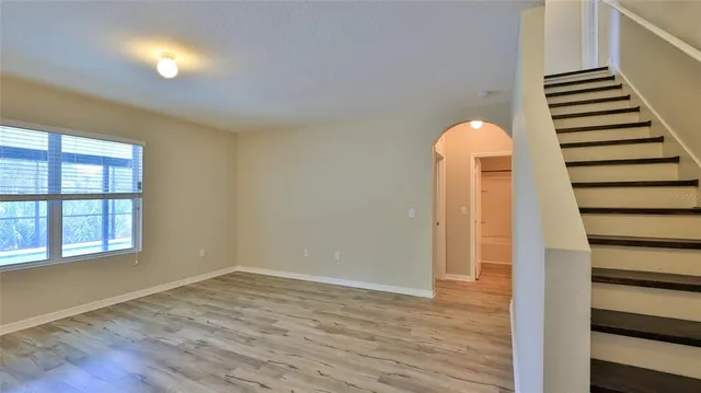 a view of a room with wooden staircase and door