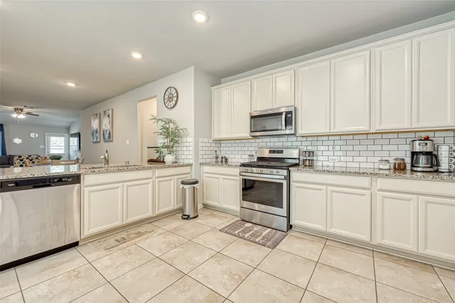 a kitchen with granite countertop white cabinets and white appliances