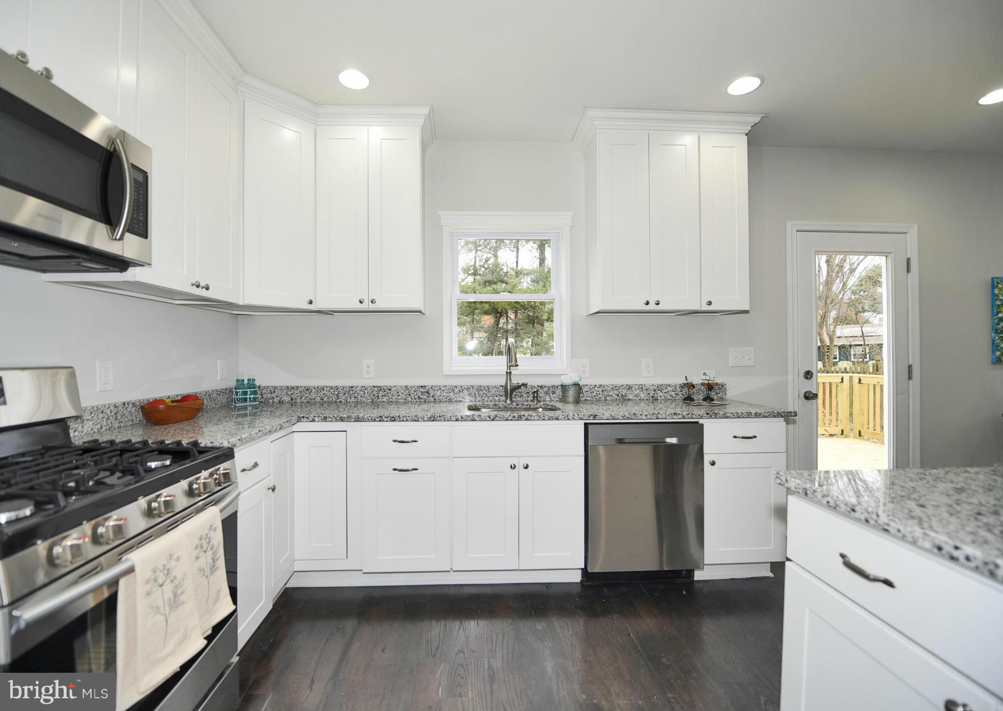 809 Cedarcroft Road Baltimore, MD 21212 - Photo 15 of 26 a kitchen with granite countertop white cabinets and white appliances