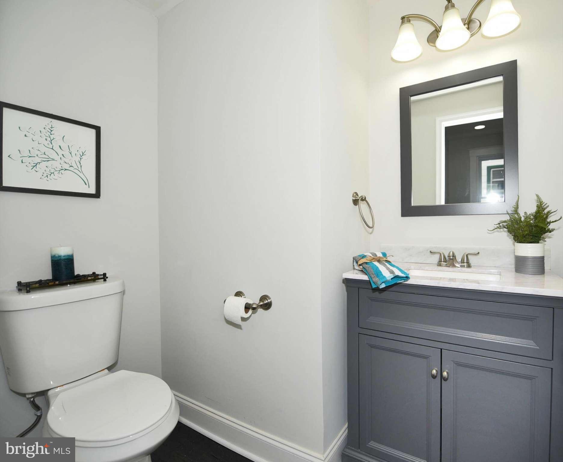 809 Cedarcroft Road Baltimore, MD 21212 - Photo 16 of 26 a bathroom with a toilet a sink and mirror