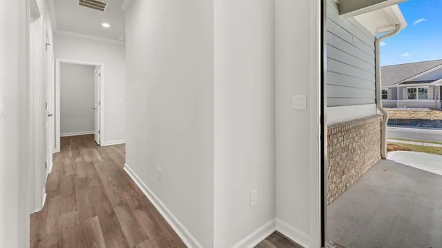 a view of a hallway with wooden floor and staircase