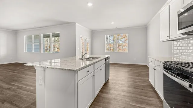 a kitchen with granite countertop a sink stove and cabinets