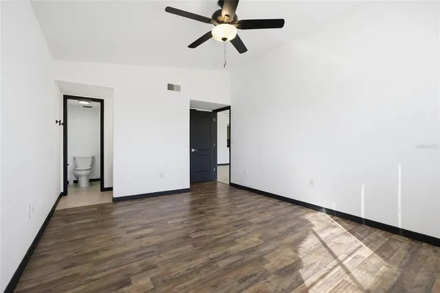 a view of an empty room with wooden floor