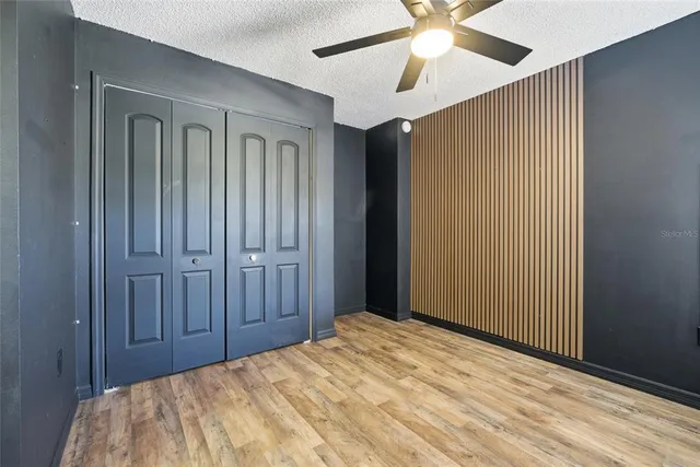 a bedroom with a bed and a chandelier fan
