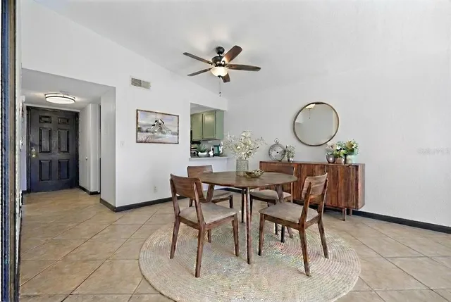 a view of a dining room and a livingroom with furniture and a chandelier fan