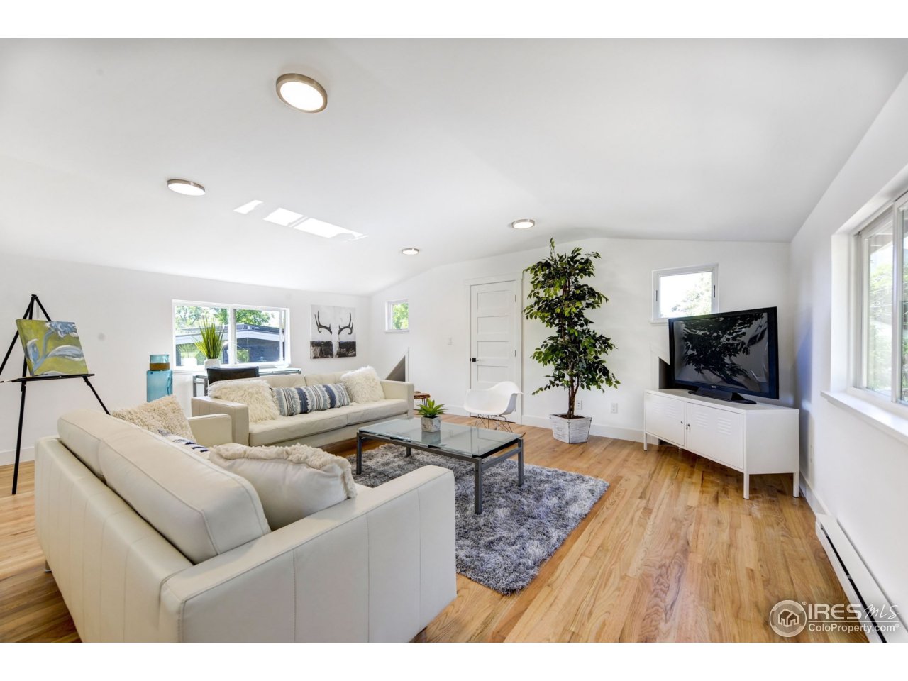 2725 6th Street Boulder, CO 80304 - Photo 38 of 40 a living room with furniture flat screen tv and wooden floor