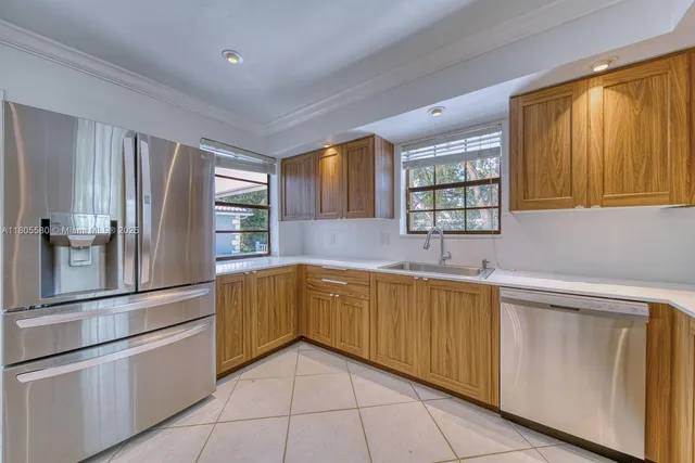a kitchen with stainless steel appliances granite countertop a refrigerator and a sink