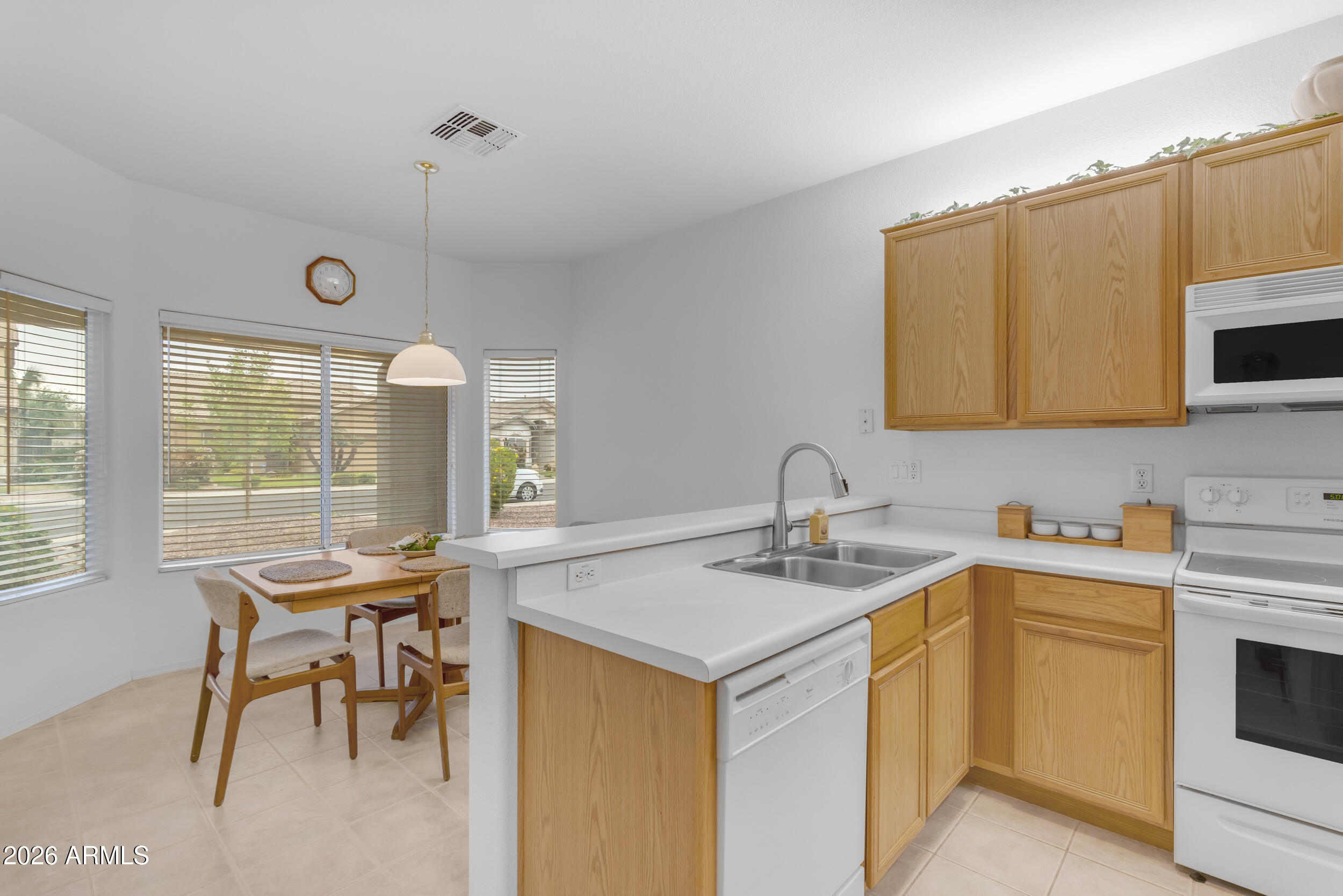 3724 East Derringer Way Gilbert, AZ 85297 - Photo 11 of 45 a kitchen with a sink a stove a table and chairs