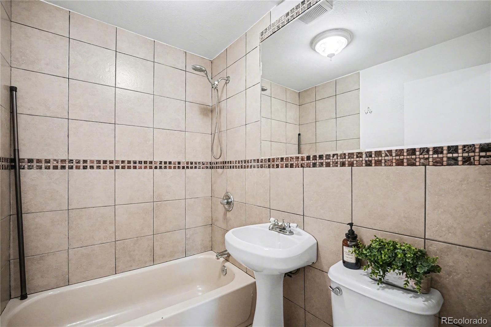 4870 Raritan Street Denver, CO 80221 - Photo 17 of 21 a bathroom with a sink toilet and shower