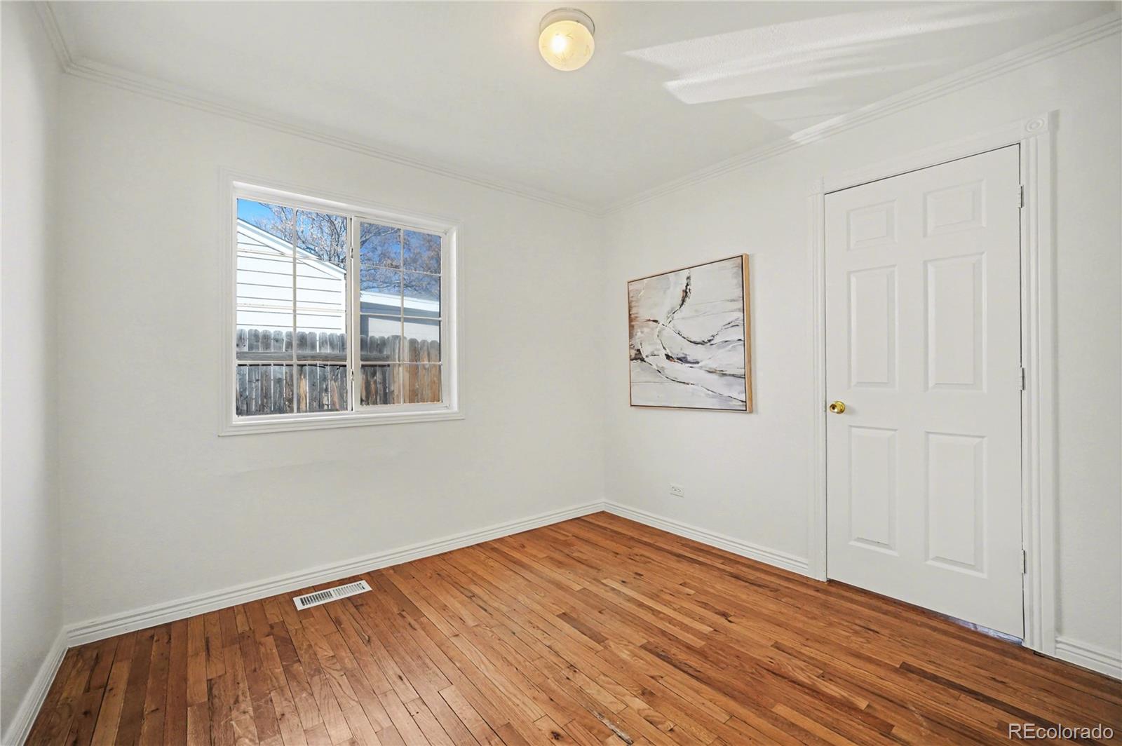 4870 Raritan Street Denver, CO 80221 - Photo 18 of 21 a view of empty room with wooden floor and fan