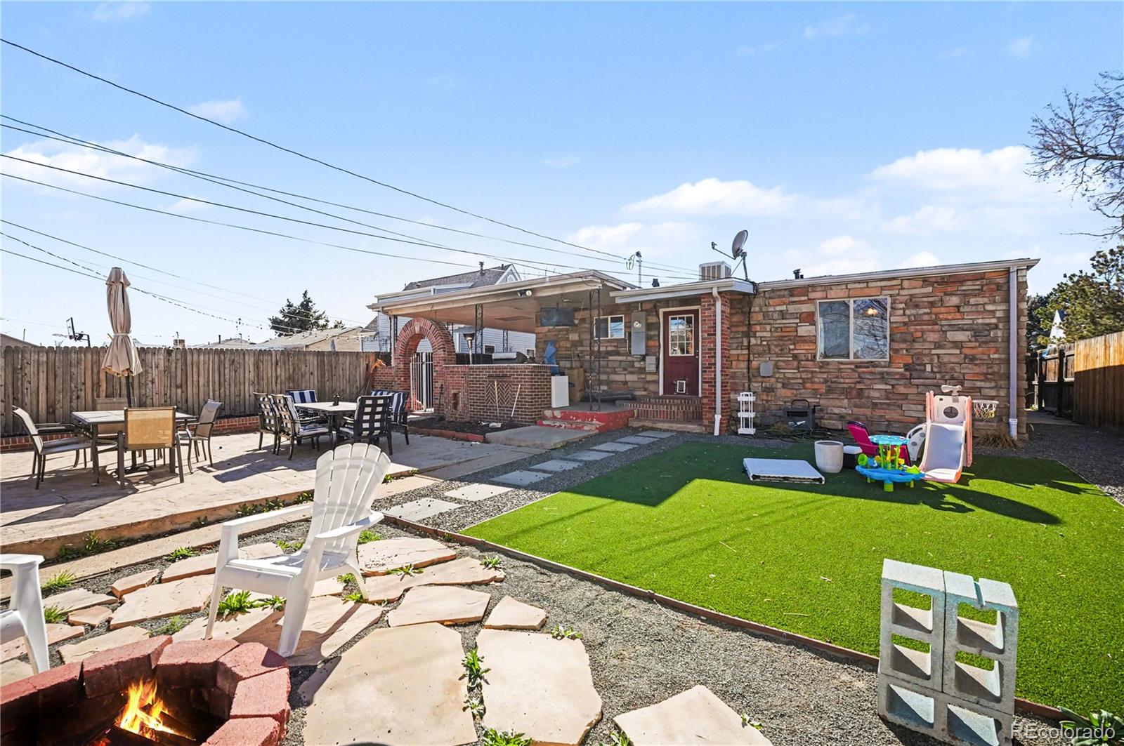 4870 Raritan Street Denver, CO 80221 - Photo 19 of 21 a view of a patio with dining table and chairs with wooden fence