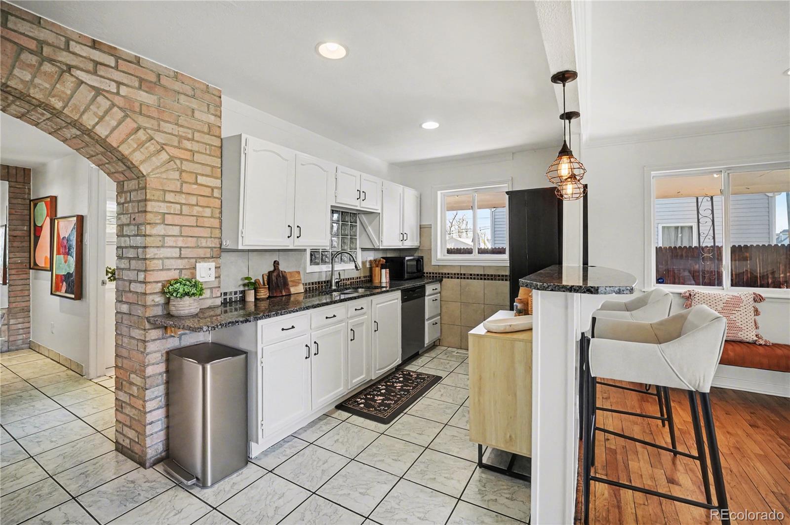 4870 Raritan Street Denver, CO 80221 - Photo 9 of 21 a kitchen with a dining table chairs and white appliances