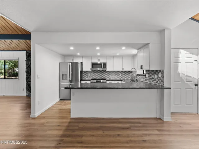 a kitchen with a dining table chairs and a refrigerator