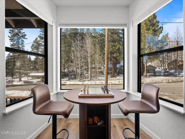 a kitchen with stainless steel appliances granite countertop a stove a refrigerator a dining table and chairs with wooden floor