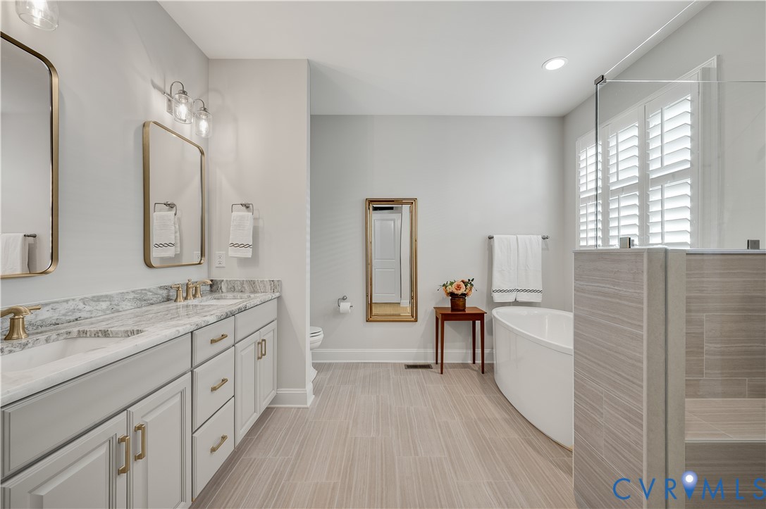9419 Widthby Road Chesterfield, VA 23832 - Photo 14 of 23 a spacious bathroom with a double vanity sink a mirror and a bathtub