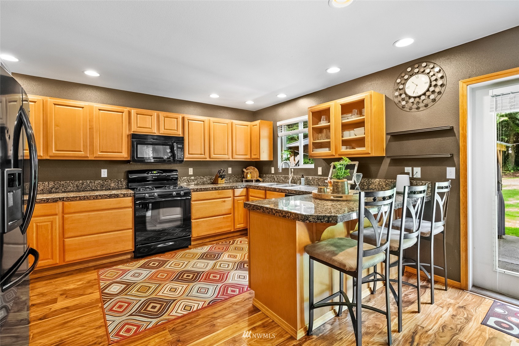 6741 Northwest Ranger Way Silverdale, WA 98383 - Photo 11 of 38 a kitchen with stainless steel appliances kitchen island granite countertop a sink and cabinets