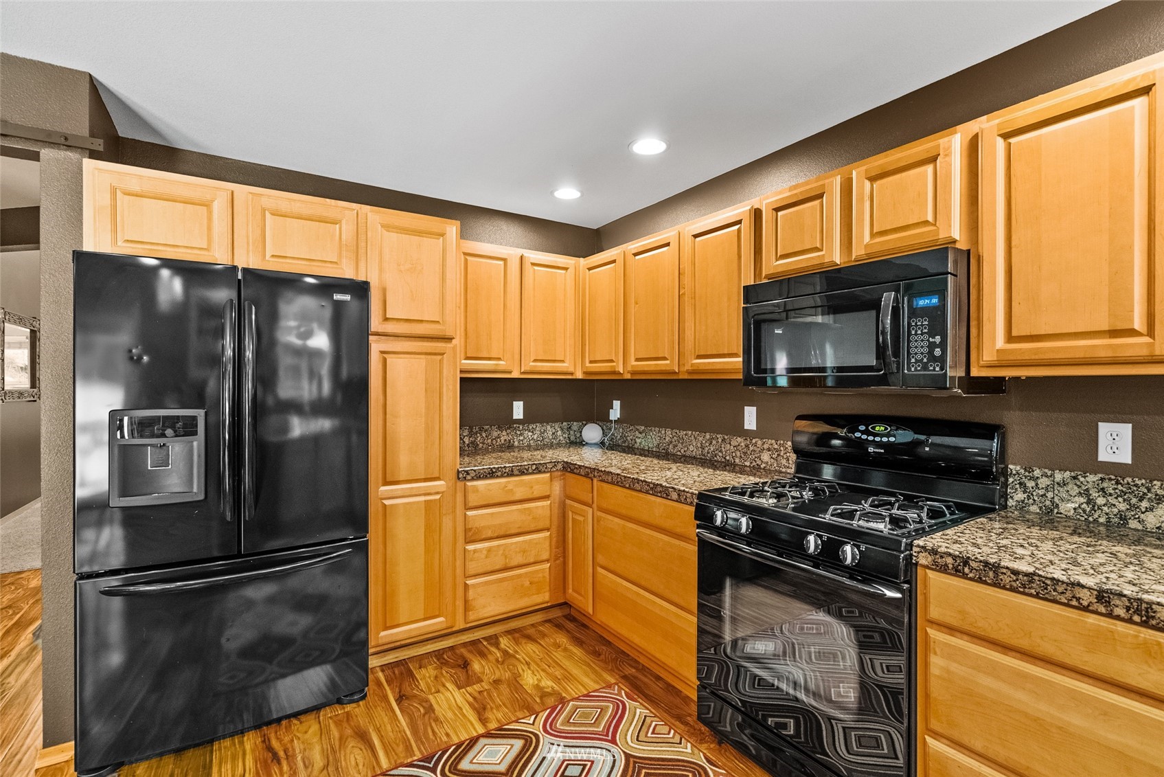 6741 Northwest Ranger Way Silverdale, WA 98383 - Photo 14 of 38 a kitchen with granite countertop a refrigerator stove top oven and sink