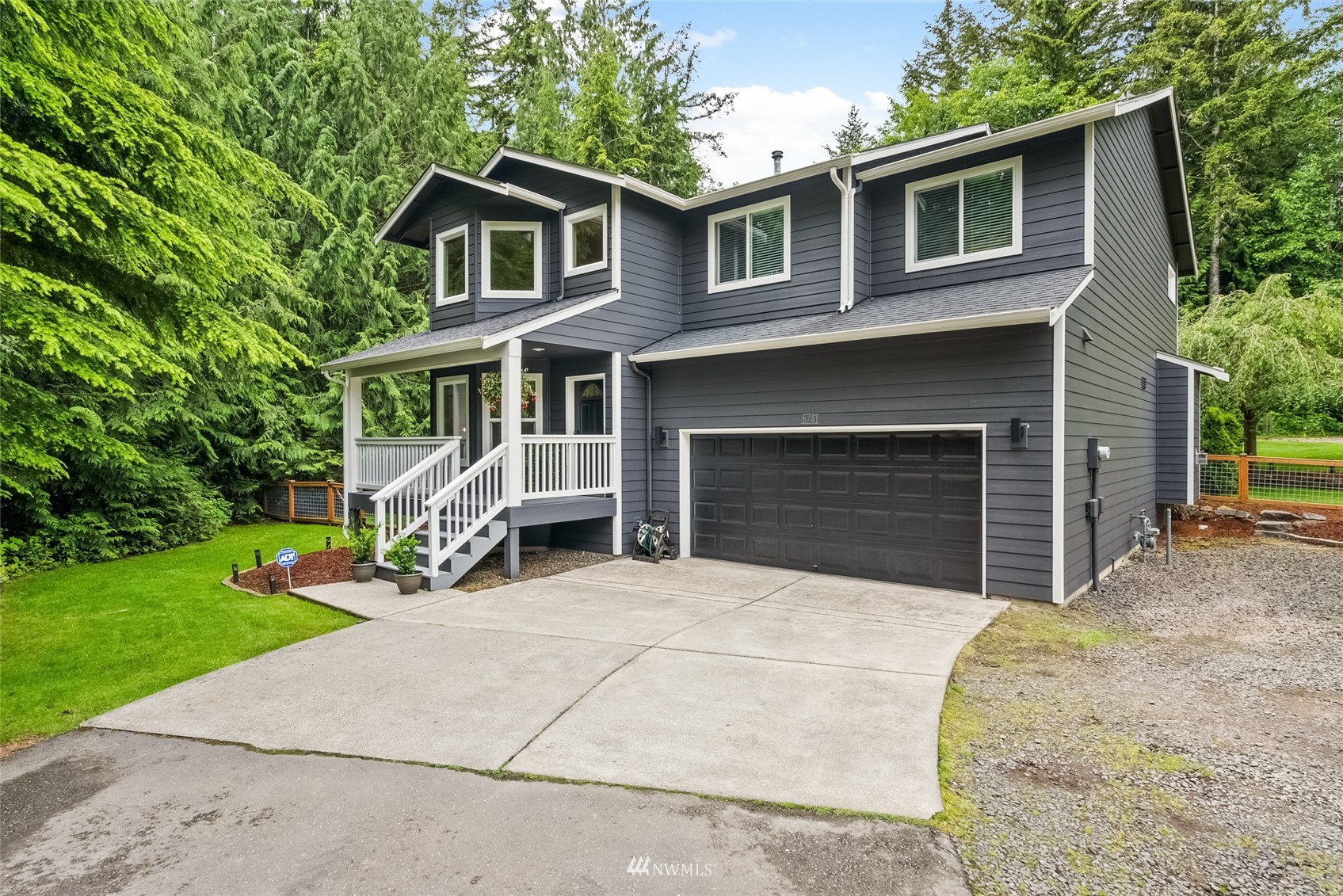 6741 Northwest Ranger Way Silverdale, WA 98383 - Photo 2 of 38 a front view of a house with a yard and garage