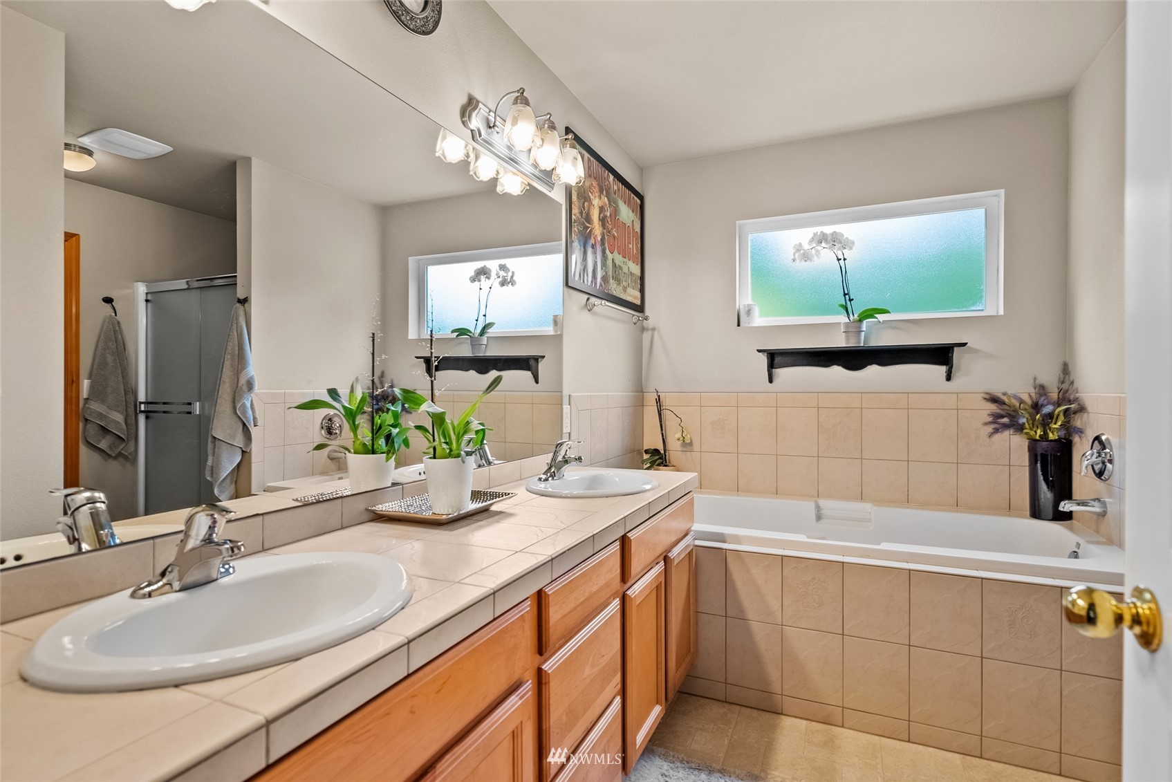 6741 Northwest Ranger Way Silverdale, WA 98383 - Photo 23 of 38 a bathroom with a double vanity sink a mirror and a bathtub