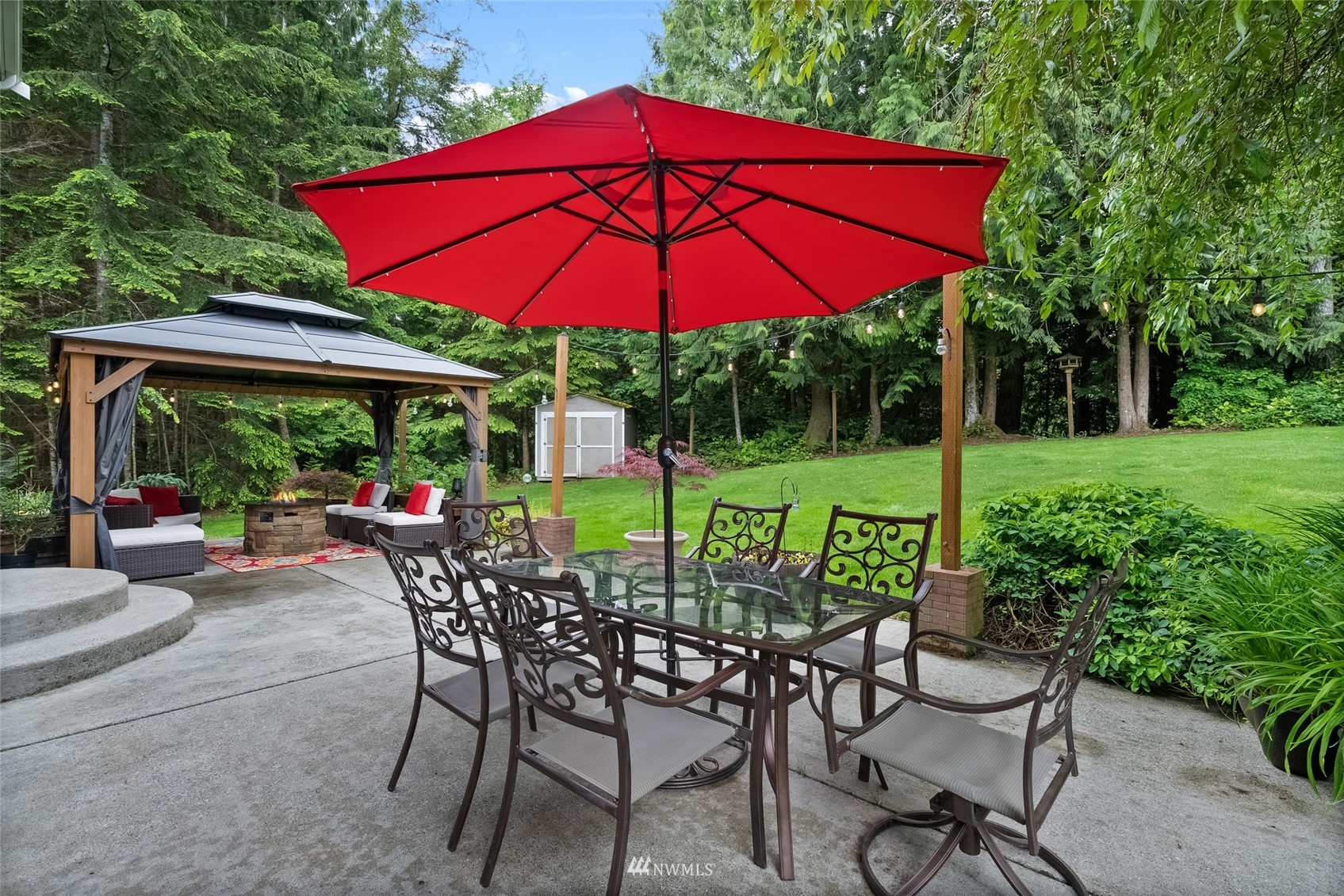 6741 Northwest Ranger Way Silverdale, WA 98383 - Photo 36 of 38 a view of patio with chairs and table under an umbrella