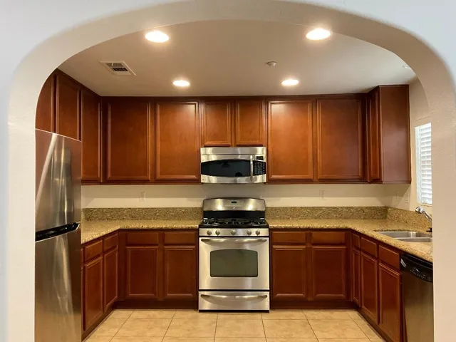 a kitchen with kitchen island granite countertop stainless steel appliances and stove