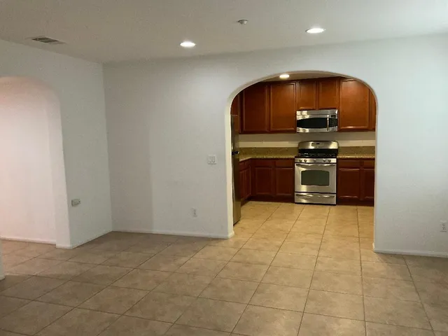 a view of kitchen with stainless steel appliances granite countertop a stove and a refrigerator