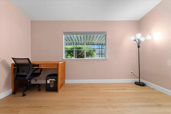 a view of a workspace with furniture and a window