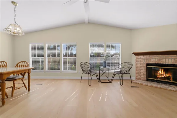 a dining room with furniture a fireplace and wooden floor