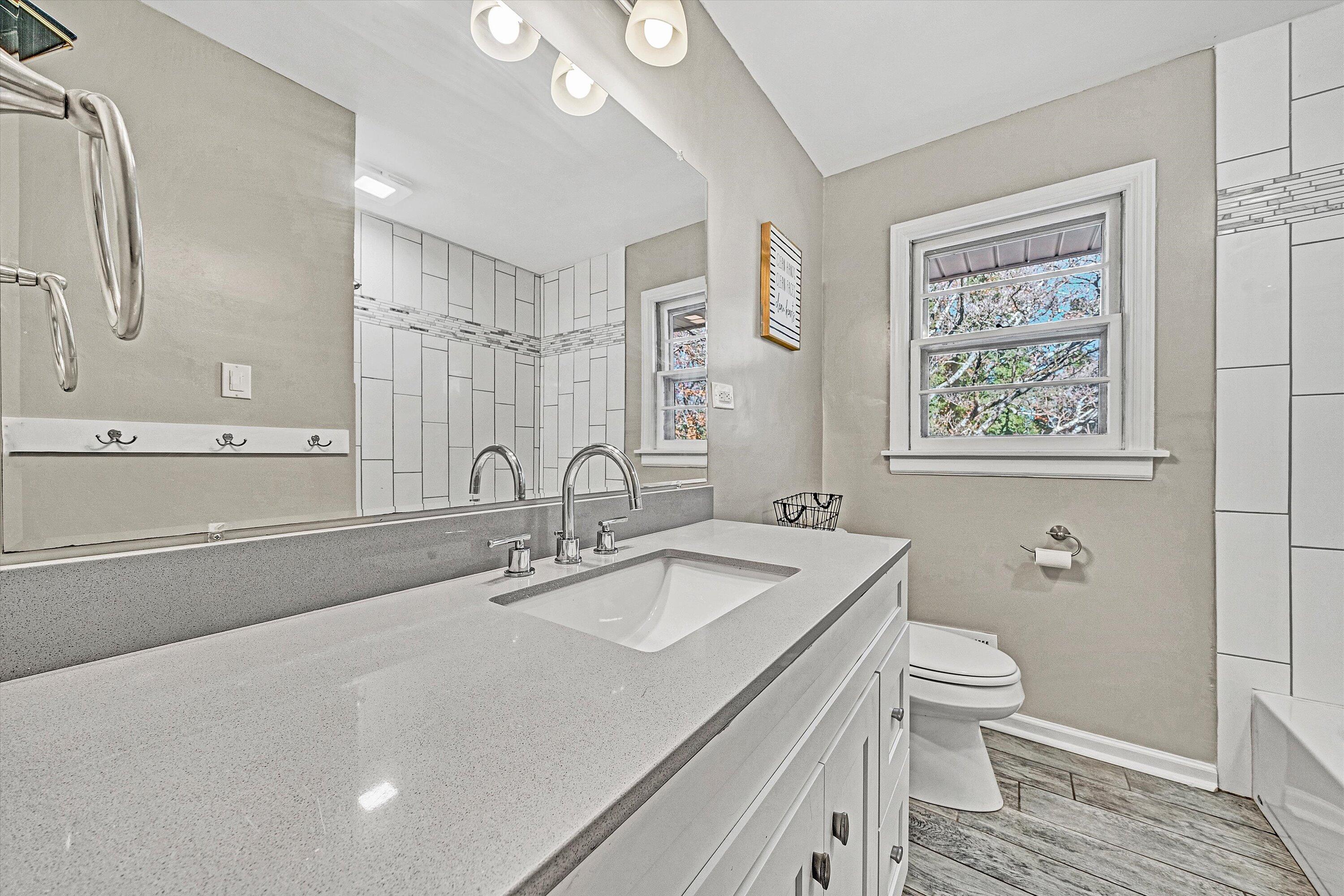 3558 Wright Road Southwest Roanoke, VA 24015 - Photo 14 of 30 a bathroom with a granite countertop sink a large mirror a toilet and a shower