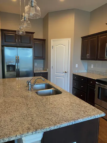 a kitchen with kitchen island sink and refrigerator