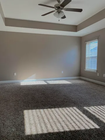 an empty room with a window and a ceiling fan
