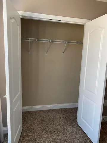 an empty room with closet and a bathroom