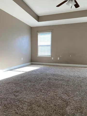 a view of a room with a ceiling fan and window