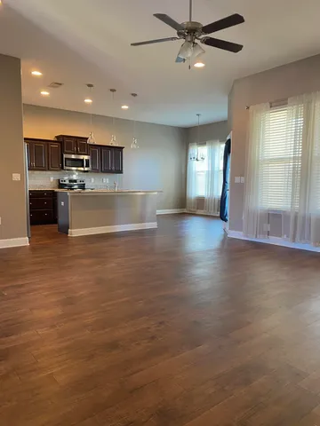 a view of kitchen and hall with wooden floor and window